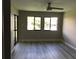 Bright living room featuring wood-look floors, a ceiling fan, and natural light from the large windows at 5178 Lake Village Drive # 86, Sarasota, FL 34235