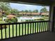 Screened lanai view of the pool surrounded by lush landscaping and manicured lawns at 5178 Lake Village Drive # 86, Sarasota, FL 34235