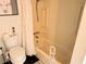 Bright bathroom with a white toilet, and a bathtub with shower and curtain at 5233 Kenwood Ave, Sarasota, FL 34234