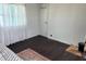 Bedroom with minimal décor, including a dark wood floor, a bed, and a window with curtain at 5233 Kenwood Ave, Sarasota, FL 34234