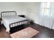 Cozy bedroom with a dark wood floor, a bed, and a vintage rug at 5233 Kenwood Ave, Sarasota, FL 34234