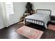 Cozy bedroom with a black metal bed frame, a rug, a window, and ample natural light at 5233 Kenwood Ave, Sarasota, FL 34234
