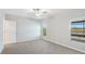 Bright bedroom with neutral carpeting, two windows with backyard views, and a ceiling fan for comfort at 5327 Olano St, Palmetto, FL 34221
