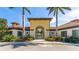Inviting clubhouse entrance with terra cotta roof, manicured landscaping, an arched entrance, and clear signage at 5327 Olano St, Palmetto, FL 34221