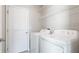 Convenient laundry room equipped with a white washer, dryer, shelving, and a utility sink at 5327 Olano St, Palmetto, FL 34221