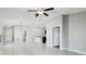 Open-concept living space with neutral walls, tile flooring, modern ceiling fan, and access to a kitchen area at 5327 Olano St, Palmetto, FL 34221