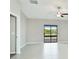 Bright, spacious living room with tile floors, ceiling fan, and sliding glass doors showcasing a serene water view at 5327 Olano St, Palmetto, FL 34221