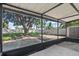 Screened-in back porch with a large tree and a storage shed overlooking the backyard at 5718 Magnolia N St, St Petersburg, FL 33703