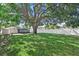 A spacious backyard features a huge tree for shade and is surrounded by a white privacy fence at 5718 Magnolia N St, St Petersburg, FL 33703