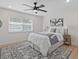 Inviting bedroom with a ceiling fan, plush bedding, and soft natural light from the window at 5718 Magnolia N St, St Petersburg, FL 33703