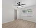 Bright bedroom with light-wood floors, ceiling fan and natural light from the large window at 5718 Magnolia N St, St Petersburg, FL 33703