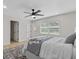 Bedroom with a ceiling fan, neutral decor, and ample natural light streaming through the window at 5718 Magnolia N St, St Petersburg, FL 33703