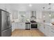 Contemporary kitchen featuring white cabinetry, stainless steel appliances, and wood-style flooring at 5718 Magnolia N St, St Petersburg, FL 33703