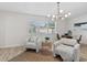 Open-concept living room with cozy chairs, a modern chandelier, and a view of the dining area at 5718 Magnolia N St, St Petersburg, FL 33703