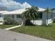 Charming white home featuring lush landscaping and vibrant plants creating inviting curb appeal at 675 El Centro # 675, Longboat Key, FL 34228