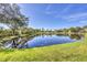 Beautiful view of a tranquil pond reflecting homes and trees, creating a serene backyard setting at 7005 Goldrush Ln, Bradenton, FL 34201