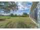 Expansive backyard with lush green grass and mature trees, perfect for outdoor activities and relaxation at 8755 Dolomite Ave, North Port, FL 34287