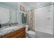 Bathroom featuring granite countertop, framed mirror and shower/tub combo with a decorative curtain at 8755 Dolomite Ave, North Port, FL 34287