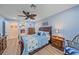 This blue bedroom features wood floors, a ceiling fan, and a wooden dresser at 8755 Dolomite Ave, North Port, FL 34287
