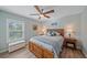 Charming bedroom features a wooden bed frame, ceiling fan, and window with plantation shutters at 8755 Dolomite Ave, North Port, FL 34287