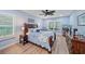 This bedroom features wood floors, a ceiling fan, and natural light from a window at 8755 Dolomite Ave, North Port, FL 34287