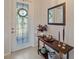Elegant foyer with decorative table, mirror, and a glass-paneled front door at 8755 Dolomite Ave, North Port, FL 34287