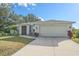 Charming single-story home with a well-manicured lawn, attached two-car garage, and inviting entryway at 8755 Dolomite Ave, North Port, FL 34287