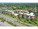 Aerial view of condo buildings surrounded by lush landscaping, mature trees, and a neighborhood at 925 Beach Rd # 408, Sarasota, FL 34242