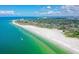 An aerial view showcasing the condo complex with nearby beach access, tropical trees, and ocean views at 925 Beach Rd # 408, Sarasota, FL 34242