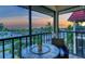 Inviting balcony space offering comfortable seating and a picturesque sunset view over the ocean and palm trees at 925 Beach Rd # 408, Sarasota, FL 34242