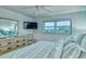 Relaxing bedroom with a dresser, mounted TV, and a window view at 925 Beach Rd # 408, Sarasota, FL 34242