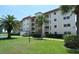 Exterior of a condo building with a red roof, green lawn, mature trees, and well-kept landscaping at 925 Beach Rd # 408, Sarasota, FL 34242