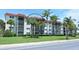 A well-maintained condo building with balconies, red roof, lush landscaping, and palm trees at 925 Beach Rd # 408, Sarasota, FL 34242