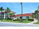 Exterior view of the building with a red roof, lush landscaping, and sidewalk at 925 Beach Rd # 408, Sarasota, FL 34242