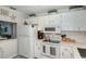 Well-lit kitchen featuring white cabinets, stainless steel appliances, and stylish decor at 925 Beach Rd # 408, Sarasota, FL 34242