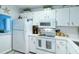 Bright kitchen with white cabinetry, modern appliances, and quartz countertops at 925 Beach Rd # 408, Sarasota, FL 34242