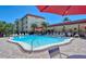 Inviting pool surrounded by lounge chairs, umbrellas, and lush landscaping, perfect for relaxation at 925 Beach Rd # 408, Sarasota, FL 34242