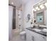 Stylish bathroom features a shower-tub combo with gray tile accents, marble counters, and chic decorative wall pieces at 1166 Blue Shell Loop, Sarasota, FL 34240