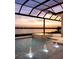 Luxury swimming pool with fountains and beautiful lake views at dusk at 1166 Blue Shell Loop, Sarasota, FL 34240