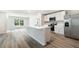 Modern kitchen with an island, stainless steel appliances, and white cabinetry, offering ample storage and counter space at 1774 Cobb Trl, Parrish, FL 34219