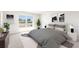 Bright bedroom showcases a large window, plush bed with patterned rug, and modern decor at 1926 Cobb Trl, Parrish, FL 34219