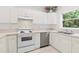 Close up of an all white kitchen with modern appliances and a stainless steel dishwasher at 2303 28Th E Ave, Palmetto, FL 34221