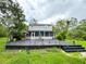 Outdoor wooden deck in backyard featuring outdoor seating, landscaping, greenery, and a grill at 25640 State Road 70 E, Myakka City, FL 34251
