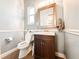 This is a half bathroom with wooden cabinets, a mirror, and a toilet at 25640 State Road 70 E, Myakka City, FL 34251