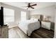 Bedroom features a large bed with upholstered headboard, wood flooring, and light-filled windows at 25640 State Road 70 E, Myakka City, FL 34251