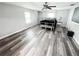 Spacious bedroom with a four poster bed frame, ceiling fan, and wood-look flooring at 25640 State Road 70 E, Myakka City, FL 34251
