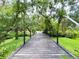 Scenic view from a wooden bridge, surrounded by lush greenery and mature trees, creating a tranquil setting at 25640 State Road 70 E, Myakka City, FL 34251