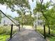 Exterior view showcasing two homes connected by a wooden bridge and lush landscaping at 25640 State Road 70 E, Myakka City, FL 34251