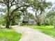 Exterior of the home featuring a welcoming entrance, lush landscaping, and a charming driveway at 25640 State Road 70 E, Myakka City, FL 34251