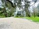 Front of two-story home with a gravel driveway, lush landscaping, and an attached garage at 25640 State Road 70 E, Myakka City, FL 34251